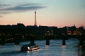 Ship moves on river to iron bridge of night in Paris