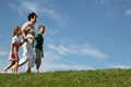 Boy and girl with grandmother go by grass