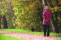 senior woman with dog in autumnal park