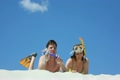 Happy pair of swimmers lies on sand
