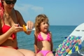 mother spreading tanner on her little daughter in pebble beach