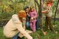 family from grandfather, mother, son and daughter collects apples