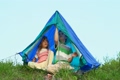 boy and his kid sister sits under tent out of town