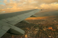 Inside a commercial passenger airplane taking off from Cape Town International Airport, South Africa.  This take-off is at dusk with the township of Gugulethu below and the Atlantic Ocean in the distance.  